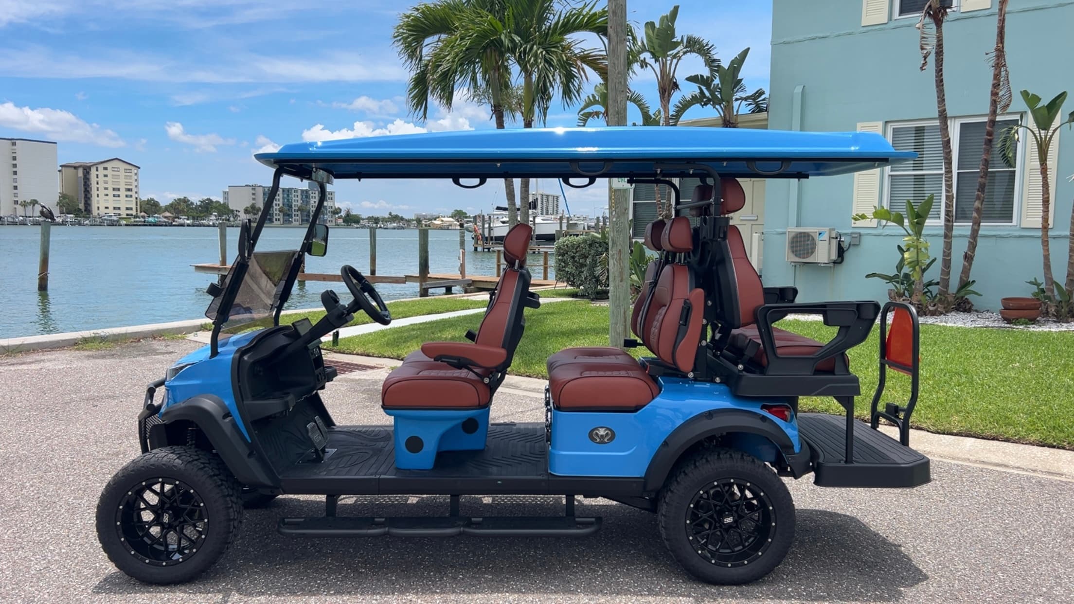 Side profile of the azure luxury 6-seater golf cart along the Intracoastal